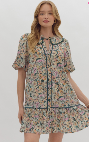 -Floral print v-neck collared short sleeve button down mini dress featuring pockets at side. Contrast solid trim detail. Scalloped trim detail at neckline. Self-tie detail at neckline. Lined. Woven. Non-sheer. Lightweight.