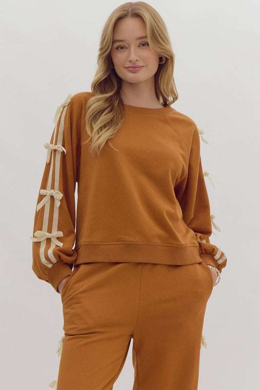 +Solid long sleeve cropped pullover featuring contrasting solid trim detail at side. Bow detail at side.