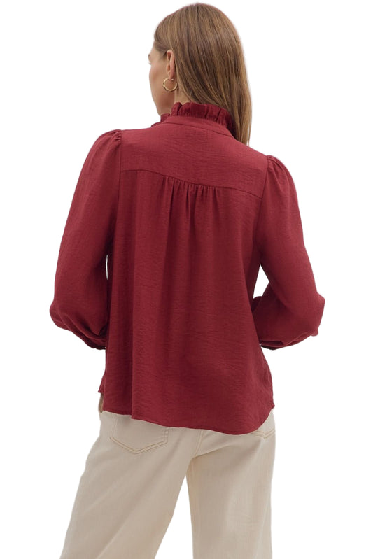 Solid long sleeve top featuring floral embroidery collar with ruffle accent